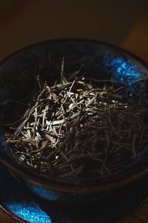 A set of dried herbal twigs displayed elegantly in a beautifully decorative bowlの写真素材