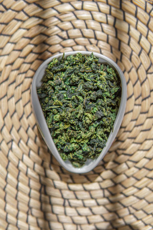 Dried Herbal Green Leaves Thoughtfully Arranged in a Decorative Bowl on a Beautiful Woven Mat