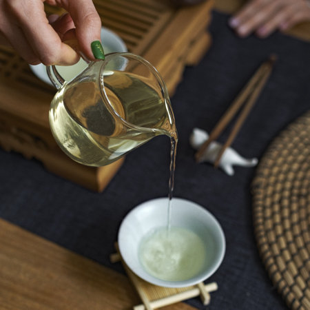The Art of Tea Ceremony Pouring Tea Gracefully into a Beautiful Cup with Care and Precisionの写真素材