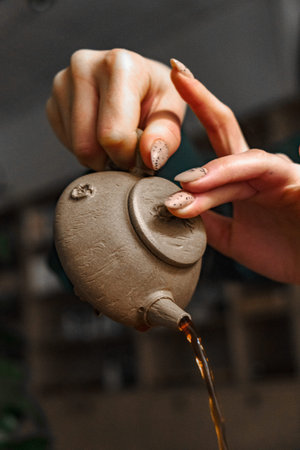 A beautifully designed elegant teapot gracefully pouring delicious tea into a cup