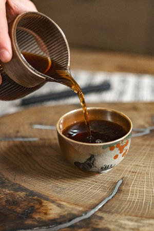 The Elegant Tea Pouring Process into a Traditional Cup creates a serene experience for tea loversの写真素材