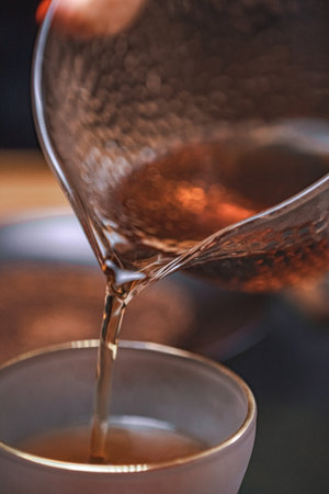 Pouring tea meticulously into a beautifully crafted delicate cup enhances the overall experienceの写真素材