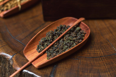 A beautifully arranged display of exquisite herbal tea leaves elegantly placed on a wooden trayの写真素材