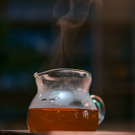A beautiful glass pitcher filled with steaming herbal tea, exuding inviting aromas and warmthの写真素材