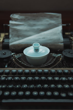 An Elegant Vintage Typewriter Accompanied by a Decorative Tea Bowl Enhances the Spaceの写真素材