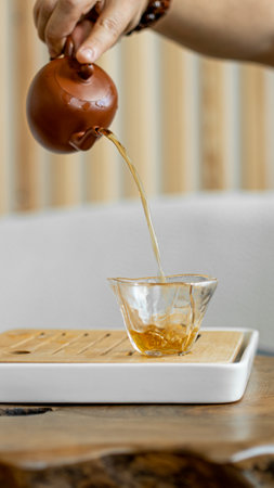 The Elegant Tea Pouring Ritual in Traditional Teaware showcases beauty and cultureの写真素材