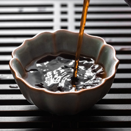Pouring a Dark, Rich Liquid into an Elegant, Beautifully Crafted Bowl for a Stunning Presentation