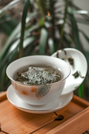 Serene Tea Experience A CloseUp of Herbal Tea Served in a Beautiful Traditional Bowlの写真素材