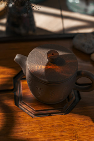 An Elegant Teapot Displayed on a Wooden Surface, Enhanced by Beautiful Play of Light and Shadows