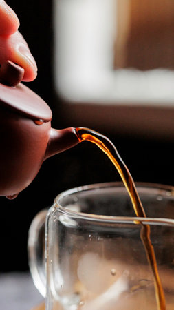 Artisan Tea Being Beautifully Poured from a Traditional Teapot with Careful Attentionの写真素材