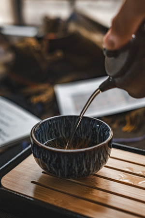 The Elegant Teapot Delicately Pouring Tea into a Beautiful and Traditional Bowl for Enjoymentの写真素材