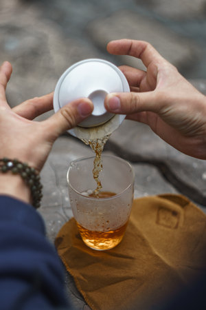 Enjoy a Refreshing Tea Moment Delicately Pouring a Sip of Natures Exquisite Brewの写真素材