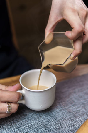 Pouring Cream into Coffee for a Perfectly Smooth and Delightful Blend of Flavors
