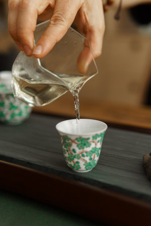 Pouring a steaming cup of tea into a beautifully decorative ceramic cup, creating an elegant momentの写真素材