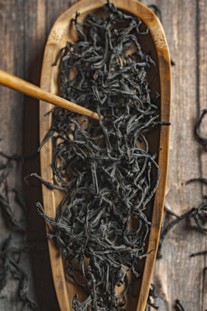 Dried Black Tea Leaves beautifully arranged in a Wooden Bowl waiting to be enjoyedの写真素材