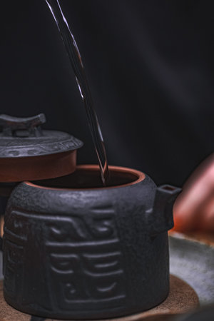 Experience the Traditional Teapot Pouring Ceremony, showcasing an Elegant Black Vesselの写真素材