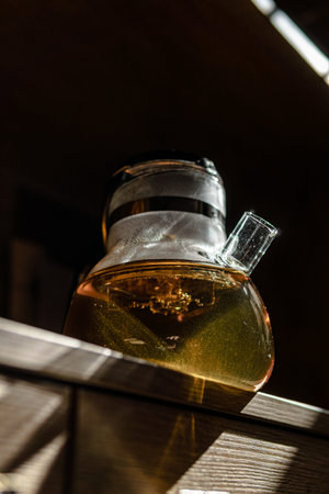 An Elegant Glass Teapot filled with Herbal Tea beautifully displayed in Natural Lighting