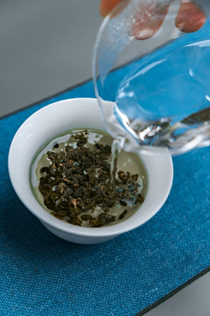 Gently pouring hot water over loose green tea leaves creates a fragrant and delightful infusion