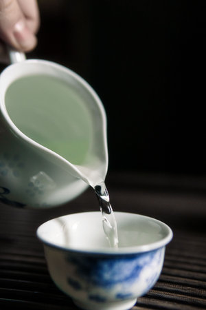 Experience the Elegant Art of Tea Pouring in Exquisite Traditional Chinese Teawareの写真素材