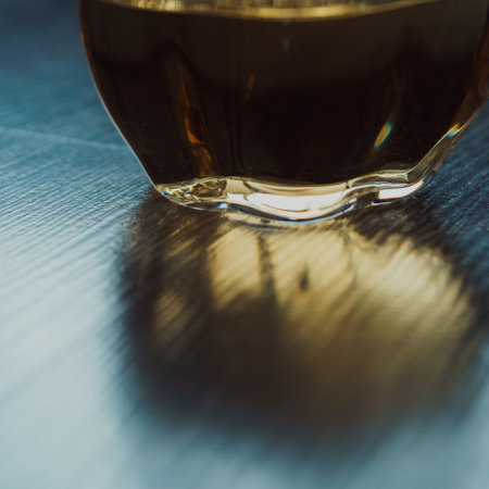 An Elegant Glass Filled with Dark Liquid on a Reflection Surface That Captures Light Beautifullyの写真素材