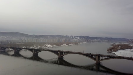 A Stunning Scenic View of a Majestic Bridge Over a Calm and Serene River During Morning Light. Stock Clipの写真素材