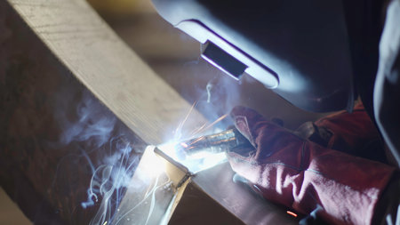 A Skilled Welder is in Action, Creating with Beautiful Sparks and Smoke Effects During the Job. Stock Clipの写真素材