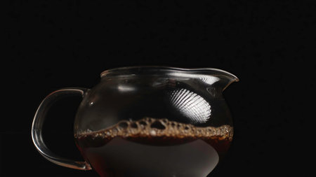 Pouring Tea in an Elegant Glass Teapot for a Refined and Enjoyable Drinking Experience. Media