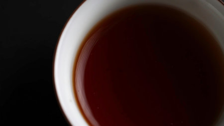 A Warm and Inviting Cup of Steaming Brewed Tea Comfortably Resting on a Dark, Rich Surface. Mediaの写真素材