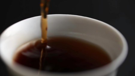 Pouring a rich and aromatic coffee into a pristine white cup against a dark background.の写真素材