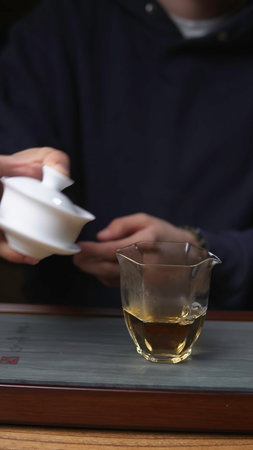 The Detailed Tea Brewing Process Using a Gaiwan and a Glass Cup for Enjoyment and Wellness. Mediaの写真素材