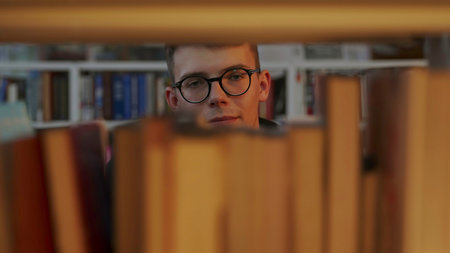 A thoughtful reader sits in a library, surrounded by books and shelves, engaging in reflection....