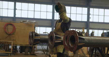 An Industrial Worker Wearing Protective Gear in a Workshop Environment While Working. Media