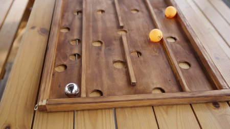 Watch orange ping pong balls navigate an engaging wooden maze. Creative