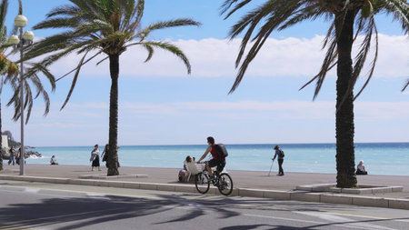 White electric car driving along the promenade des anglais in nice, france.の写真素材
