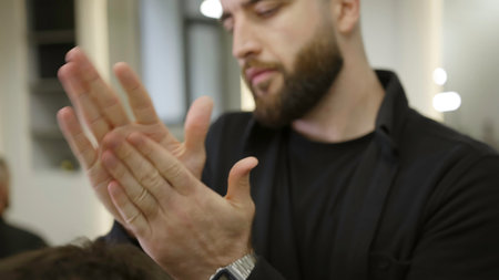 Professional barber styling clients hair with wax. Clipの写真素材