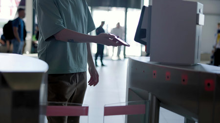 People passing through turnstile using smartphone nfc technology. Media