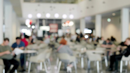 Many people relaxing and eating in a defocused food court.の写真素材