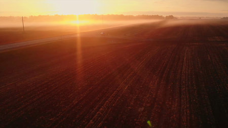 Golden sunrise over a foggy rural landscape.