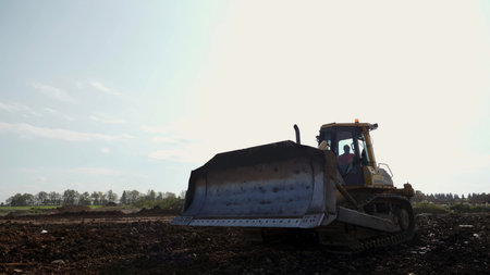 Yellow bulldozer moving dirt on construction site. Clip