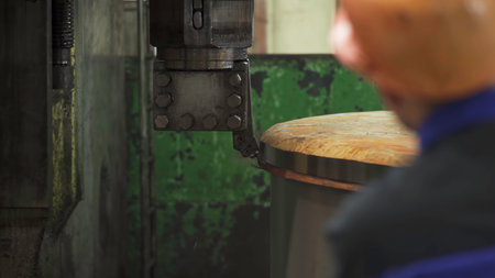 Industrial machine cutting metal edge with worker supervising. Stock clipの写真素材