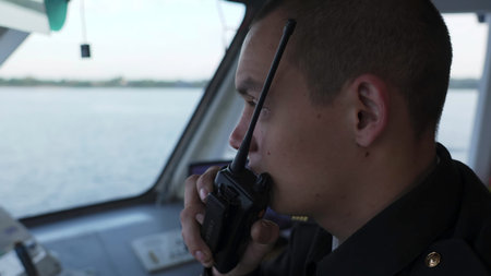 Sailor communicating with walkie talkie on a ship. Clip