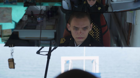 Captain steering ship, seen from cabin window reflection. Clip