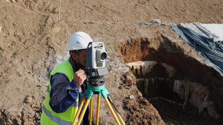 Surveyor using theodolite total station on construction site. Clip