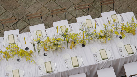 Elegant white table setting with yellow flowers and lemons. Action