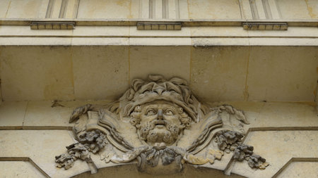 Mascaron adorning building facade, architectural detail.