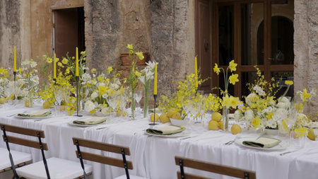 Elegant long table decorated with yellow flowers and lemons for a rustic chic outdoor event. Action