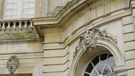 Elegant stone woman face carving adorning french chateau window.の写真素材