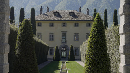 Elegant villa with italian garden and cypress trees in the alps.の写真素材