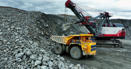 Excavator loading ore into mining truck. Stock clip