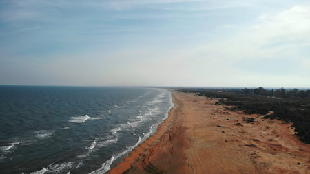Aerial view of waves crashing on sandy beach. Media